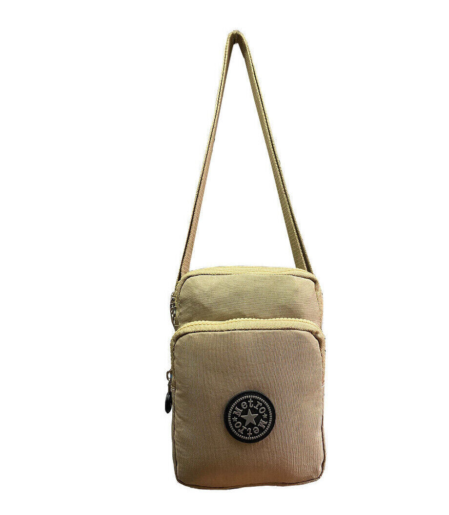 A beige canvas crossbody bag with a single shoulder strap and a black circular logo patch on the front pocket, shown against a plain white background.