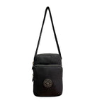 A black canvas crossbody bag with a front zippered pocket and a circular  logo patch, shown against a plain white background.