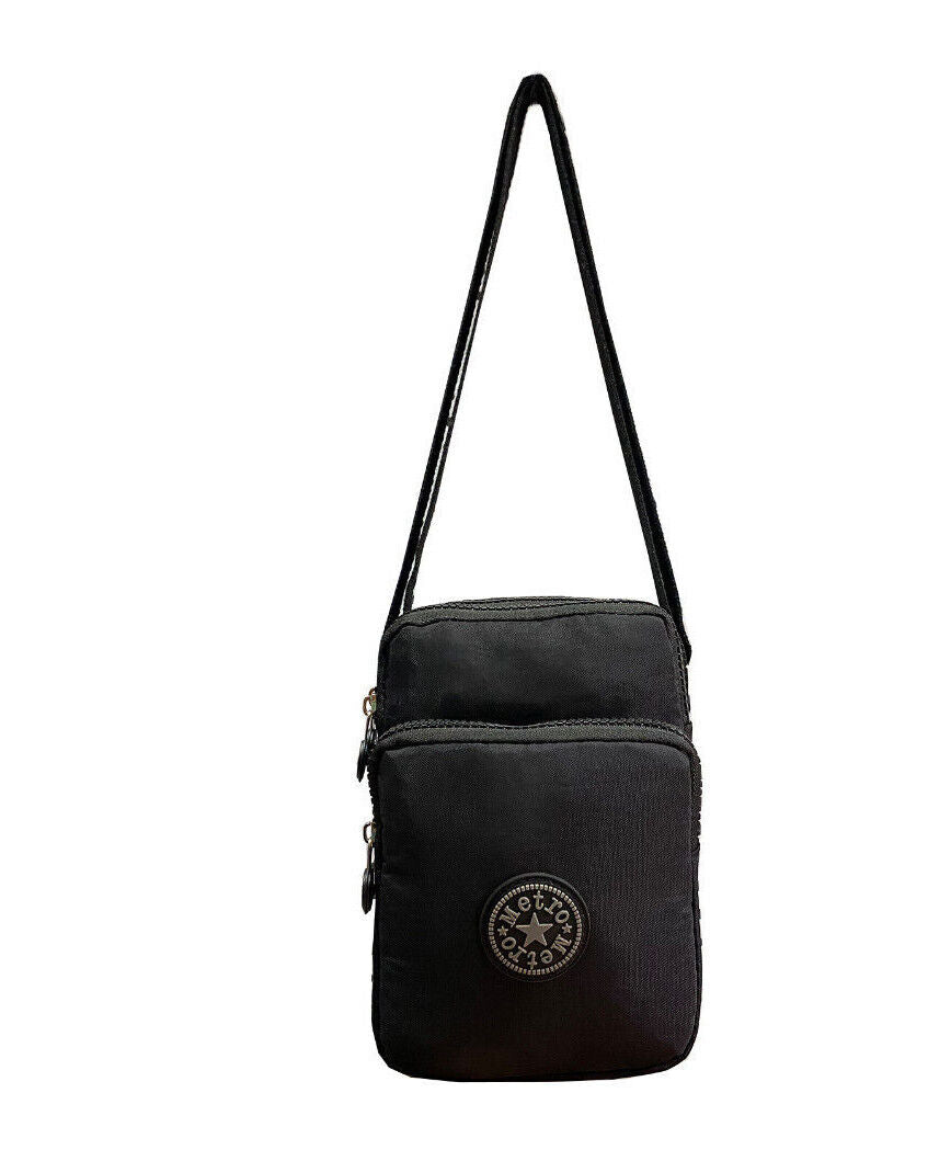 A black canvas crossbody bag with a front zippered pocket and a circular  logo patch, shown against a plain white background.
