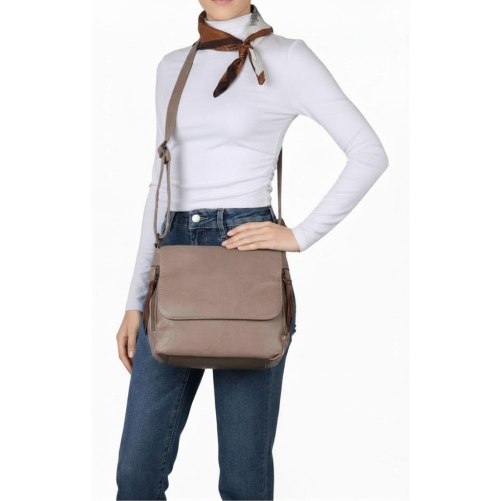 Leather-look vegan crossbody bag worn over the shoulder showing twin side zip pockets and magnetic front flap