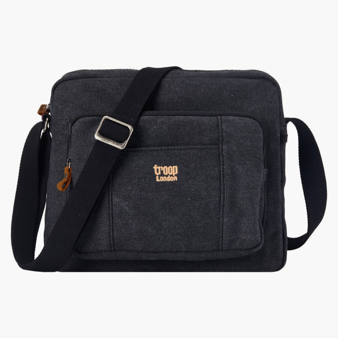 Black Troop London Large Canvas Cross-body Bag - A4 Size & Brass Hardware with a black adjustable shoulder strap, and a small tan 'troop London' logo on the front pocket, shown against a plain white background.