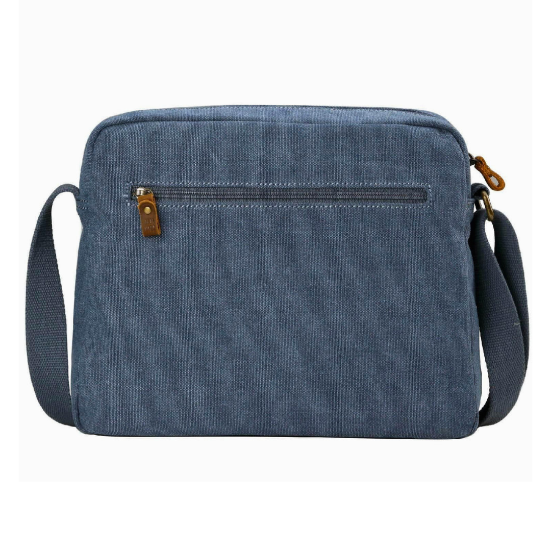 A blue canvas Troop London Small Canvas Cross-body Bag - Lightweight & Brass Hardware with a front zippered pocket, brown leather zipper pull, and a matching blue shoulder strap, shown against a plain white background.