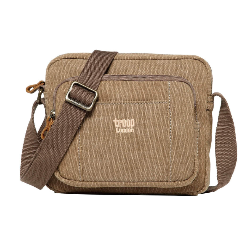 A brown canvas crossbody bag with a matching brown adjustable shoulder strap. The front pocket features the 'troop london' logo in beige.